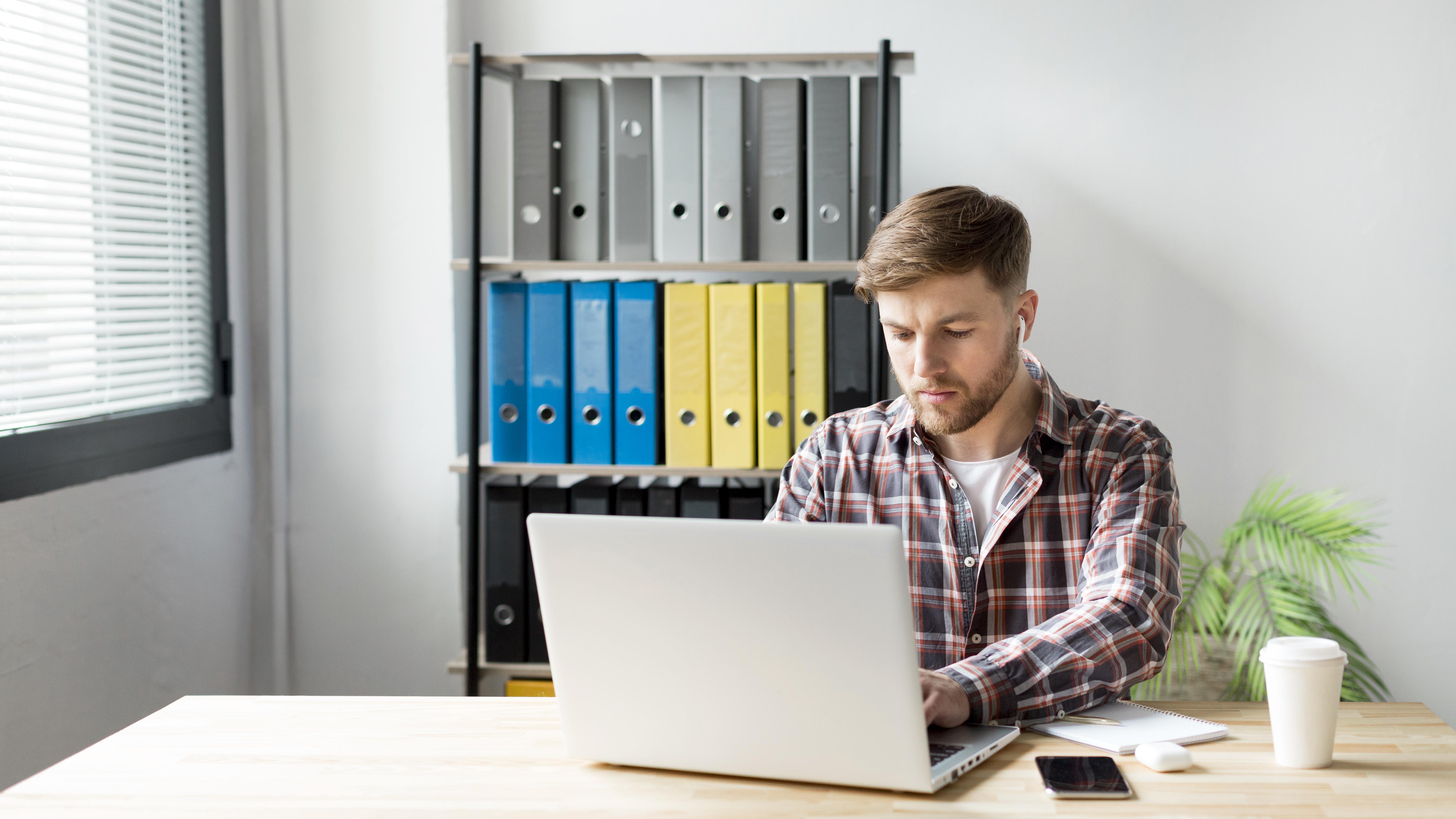 A person typing a document on a laptop.
